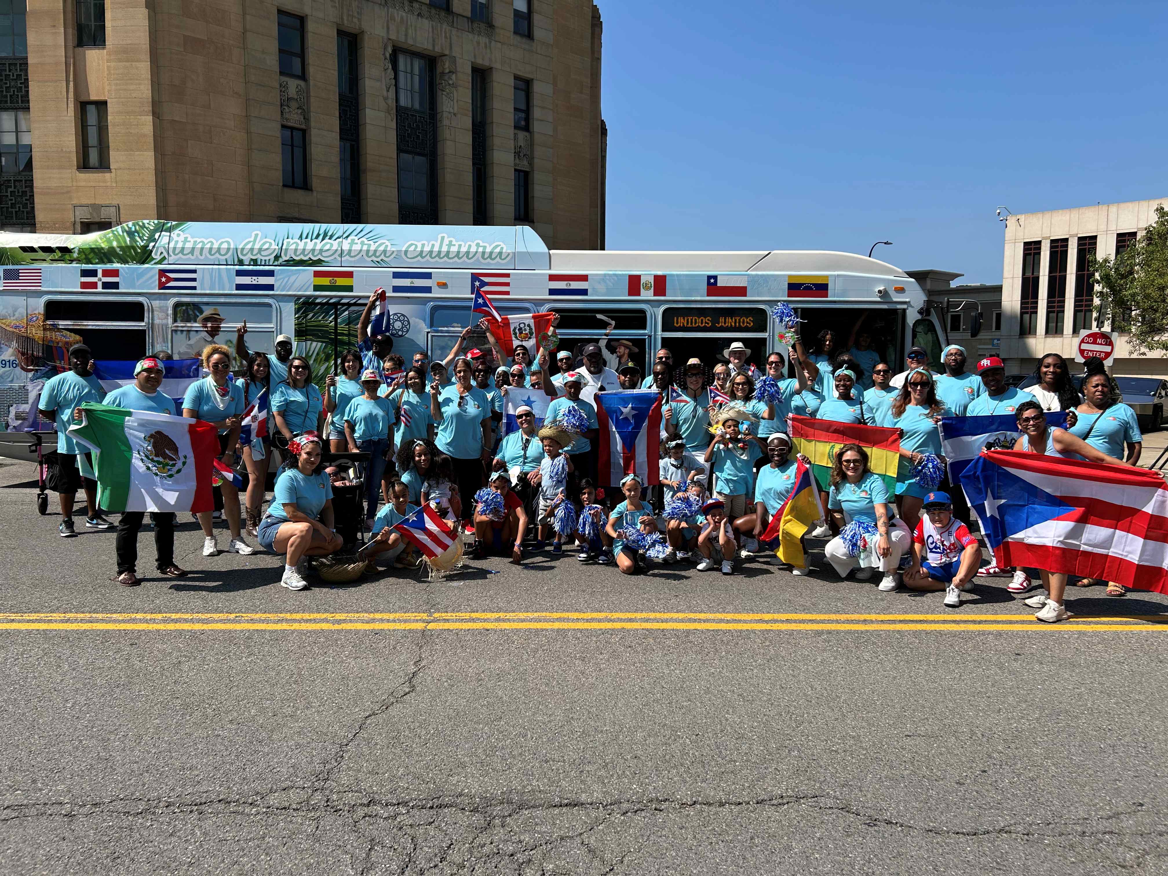 Group photo in front of PR and Hispanic Pride bus